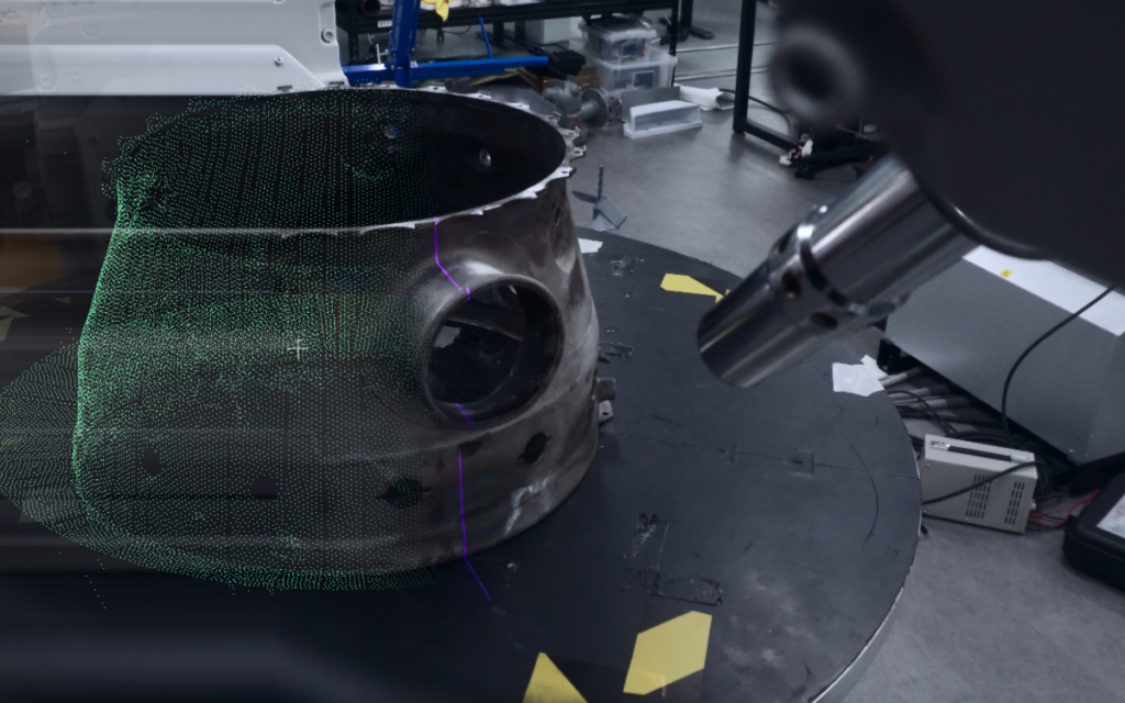 3D scanner capturing a continuous point cloud scan of a combustor casing on a turntable for automated toolpath planning
